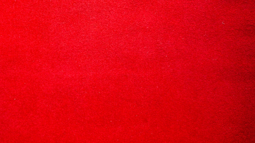 a red carpet with a black cat laying on top of it